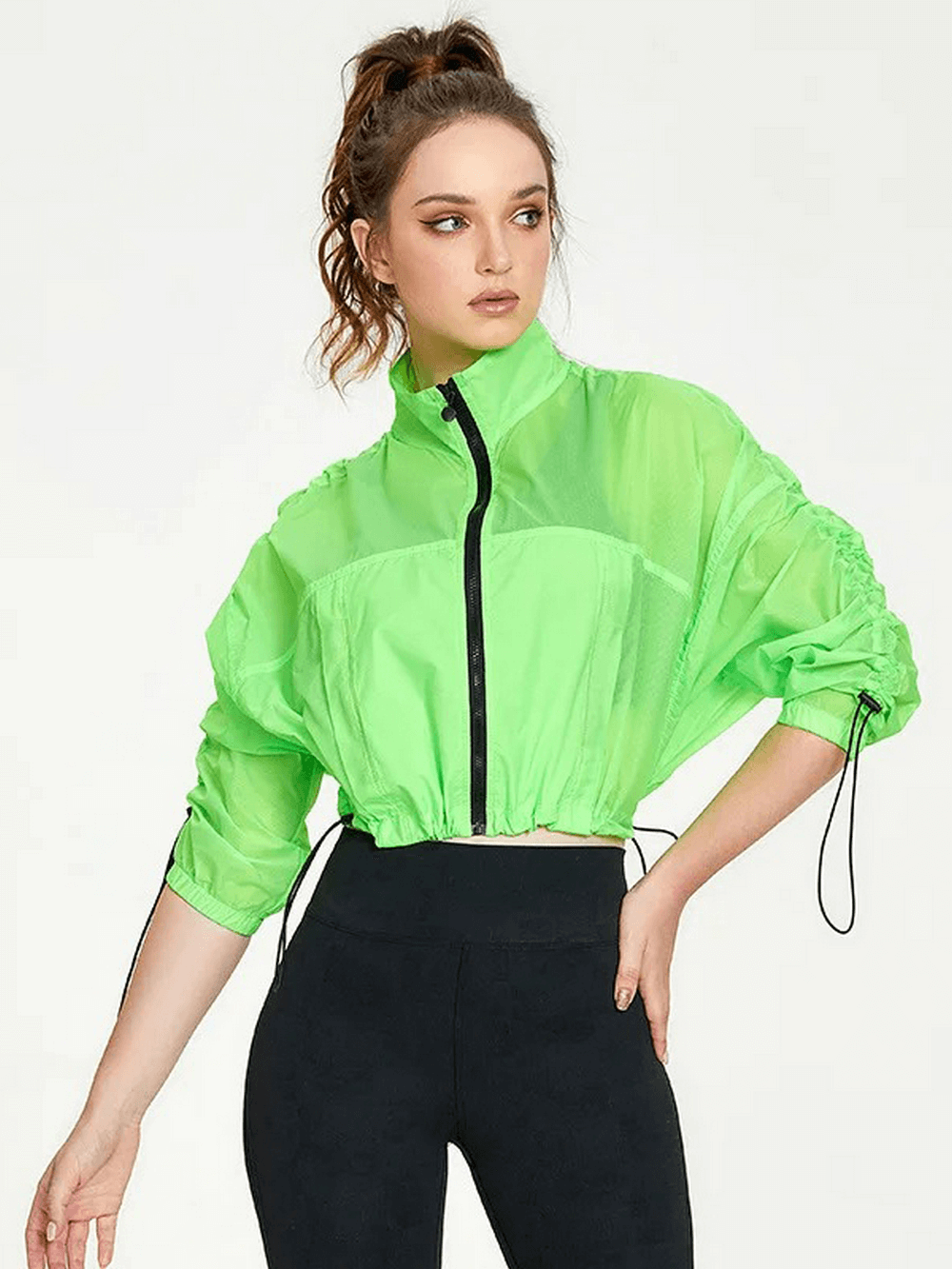 Women's neon windbreaker jacket with full sleeves, stylish and breathable, perfect for outdoor workouts. Model wearing green jacket.